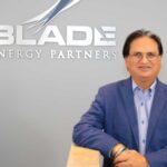 Suri standing in front of Blade Energy Partners sign